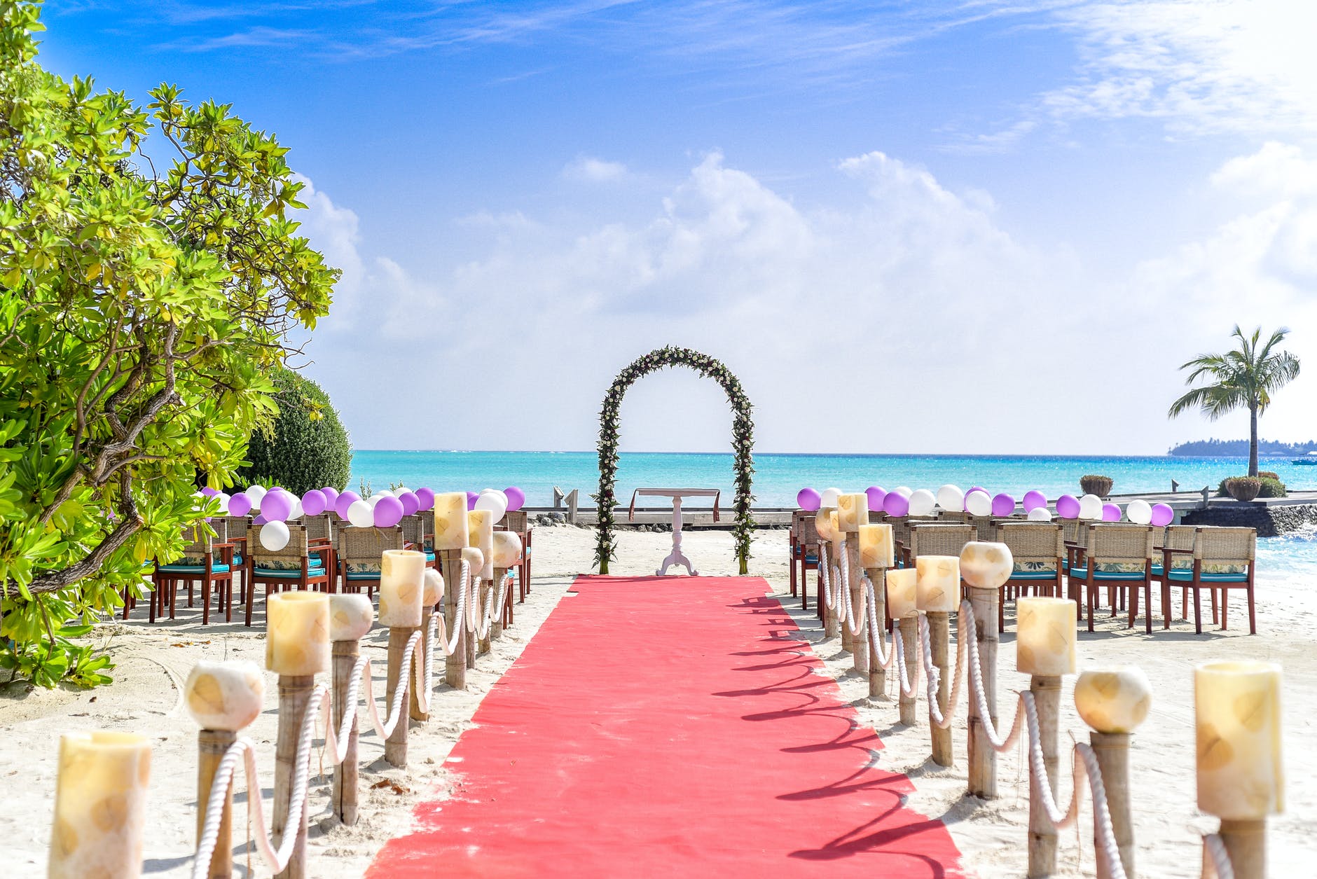 beach wedding event under white clouds and clear sky during daytime